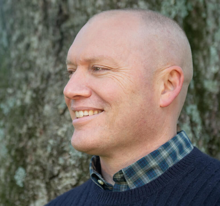Aaron Patton Author smiling in front of a tree